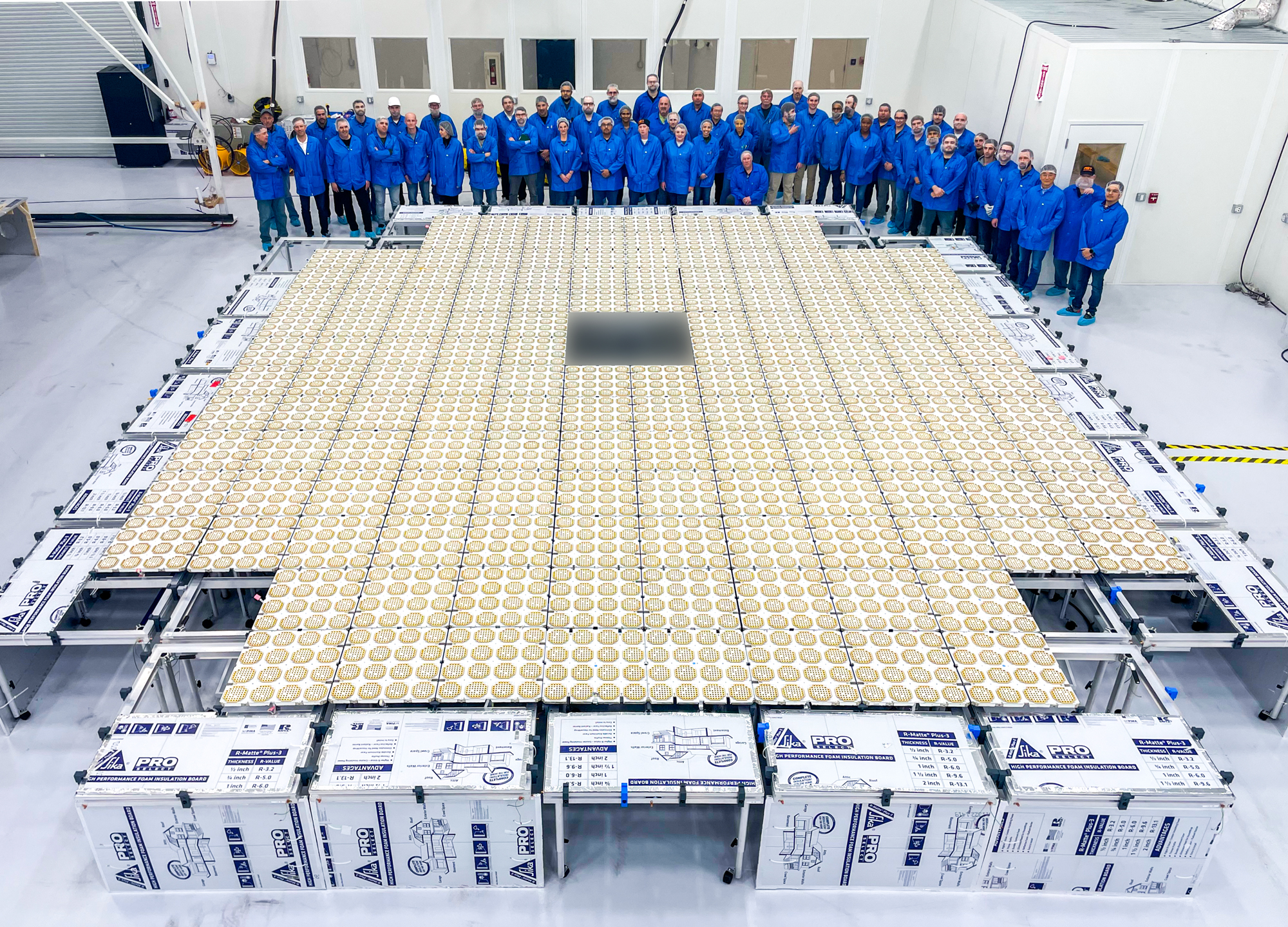 On March 18, 2022, AST SpaceMobile staff stand behind the Earth-facing, antenna-lined side of Micron panels that were later assembled into the BlueWalker 3 test satellite's phased array (nearly 700 sq ft in area). The satellite was used to conduct the first-ever voice calls, data downloads, video calls, and streaming video playback from unmodified phones connected directly to a satellite in space using terrestrial cellular frequencies.