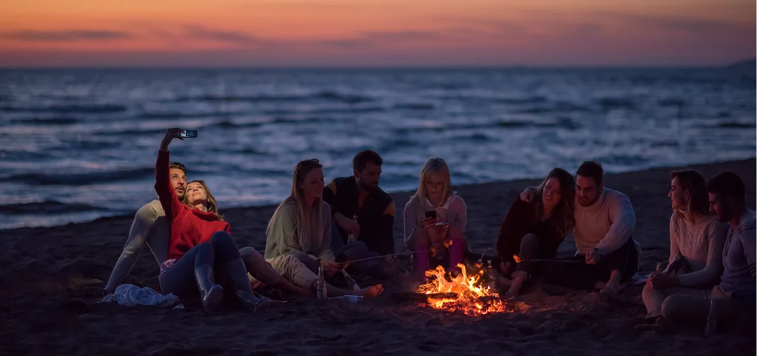 group gathering on beach with mobile service